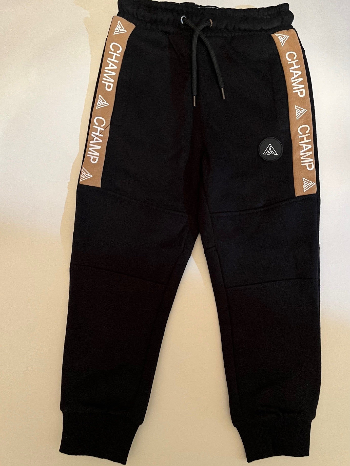 Ensemble jogging sport-veste beige a capuche zippé et jogging noir.