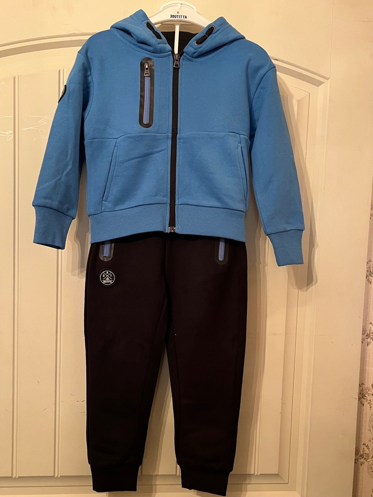 Ensemble jogging sport-veste bleu a capuche zippé et jogging noir.