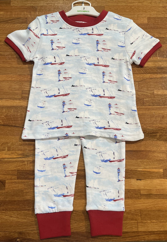 Pyjama sur font bleu pale et blanc avec des motifs nautique de voilier et de phares.