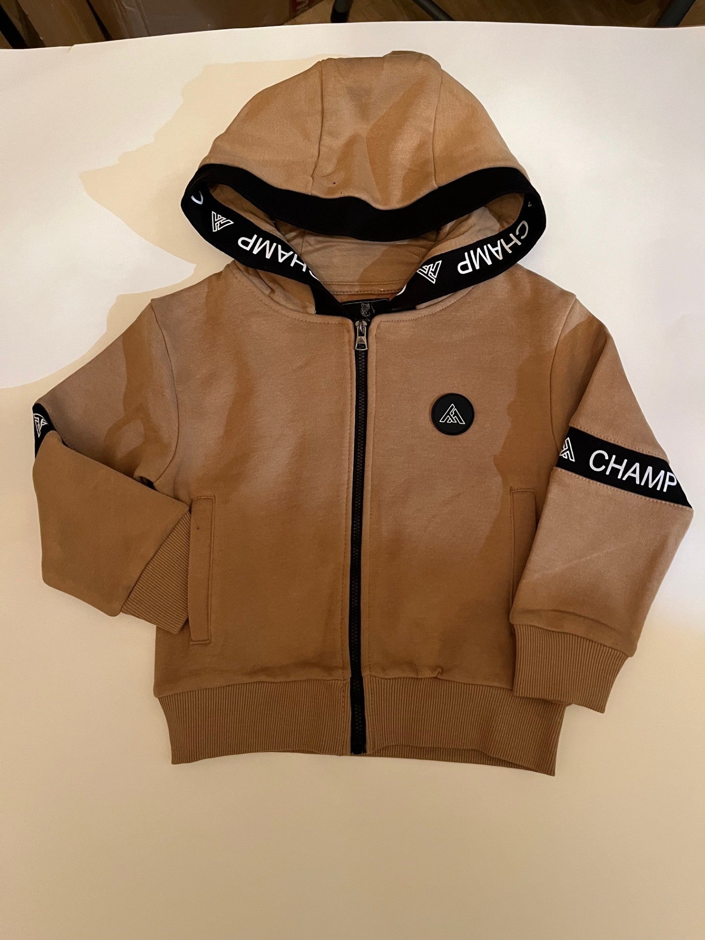 Ensemble jogging sport-veste beige a capuche zippé et jogging noir.
